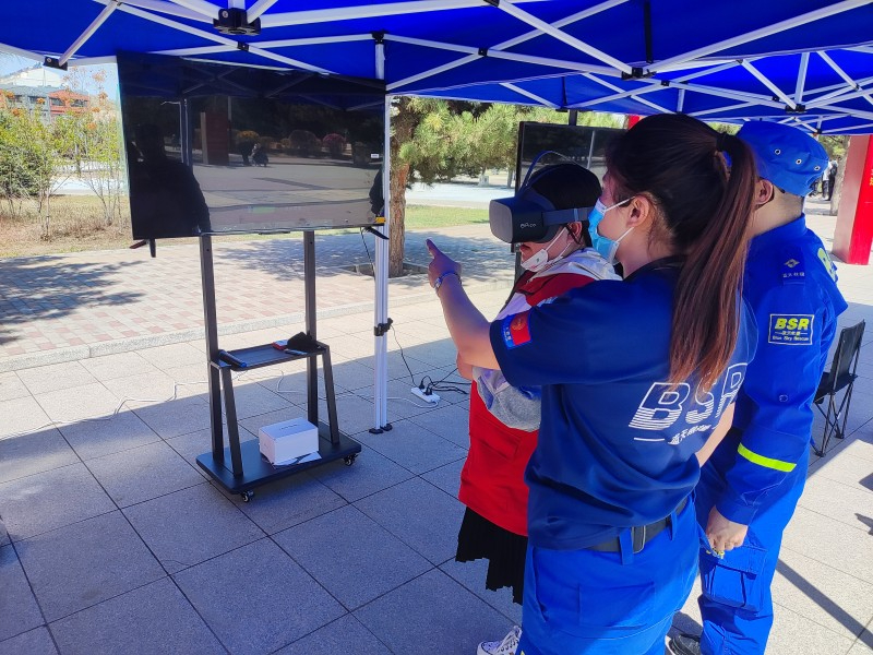 刘宇祺引导群众体验流动生命安全体验站的VR眼镜 
